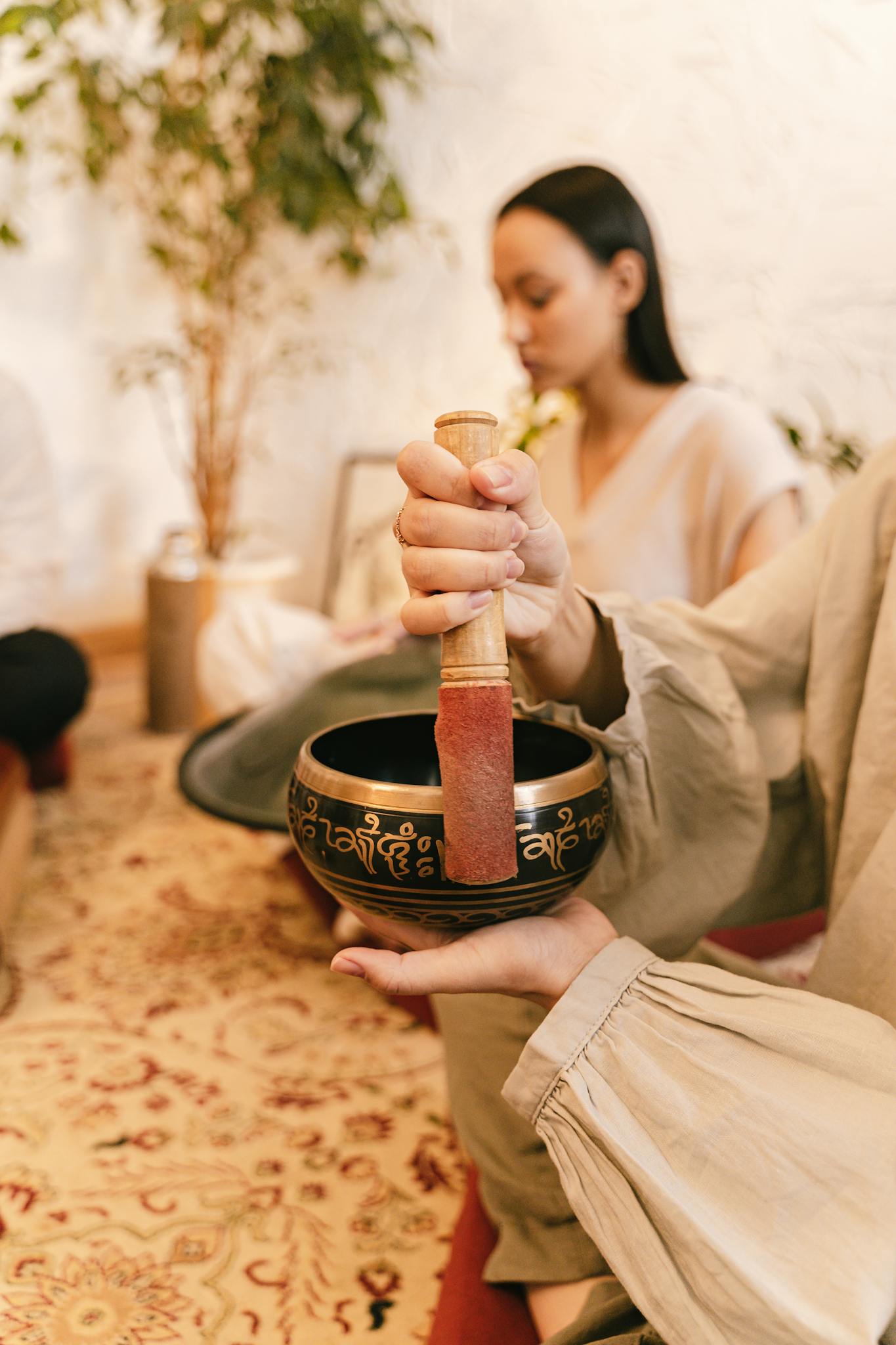 A calming scene of a Tibetan singing bowl used during a meditation session indoors.